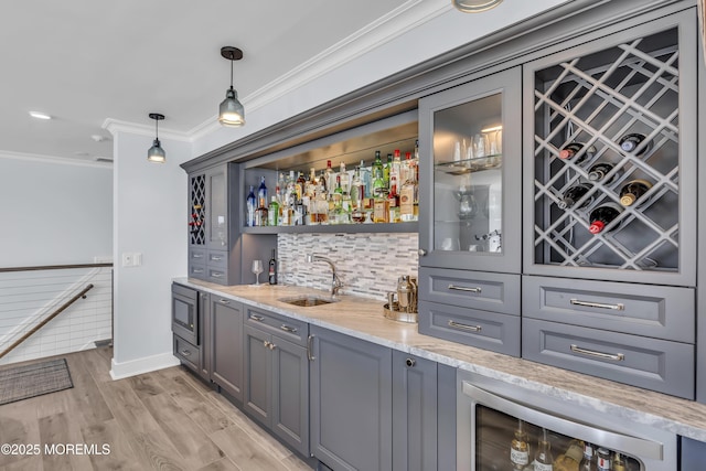 388 Ocean Ave N Unit 6D, Long Branch, NJ 07740 - indoor wet bar featuring crown molding, beverage cooler, light wood finished floors, hanging light fixtures, and backsplash