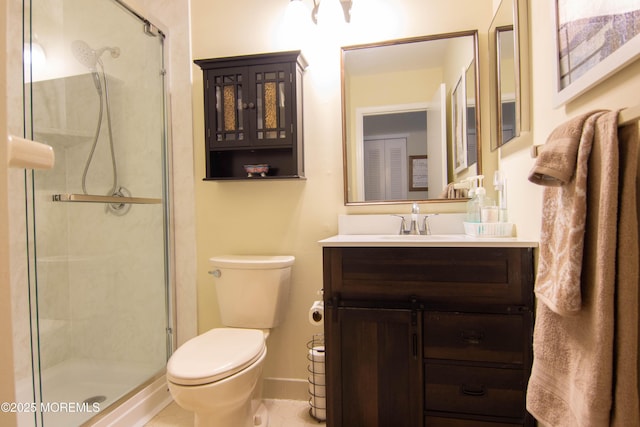 bathroom with vanity, toilet, and a shower with shower door