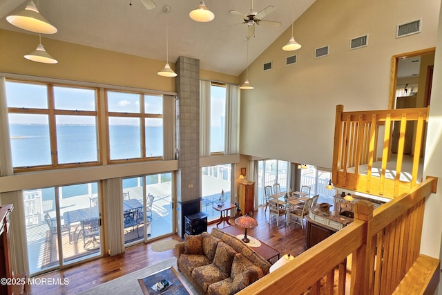 living area with visible vents, plenty of natural light, and wood finished floors