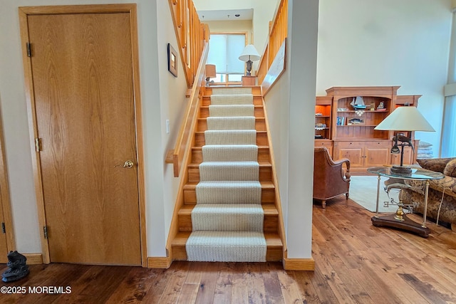 staircase with wood-type flooring and baseboards