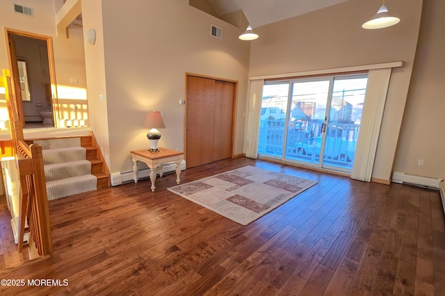 entryway with high vaulted ceiling, a baseboard radiator, dark wood-style flooring, visible vents, and stairway