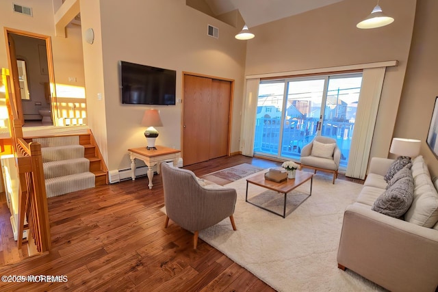 living area featuring high vaulted ceiling, visible vents, a baseboard heating unit, and wood finished floors