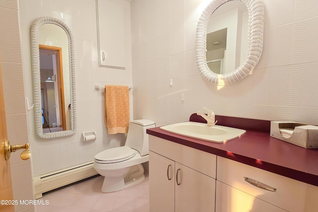 bathroom featuring toilet, a baseboard radiator, tile patterned floors, vanity, and tile walls