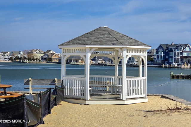 view of dock with a water view, a residential view, and a gazebo