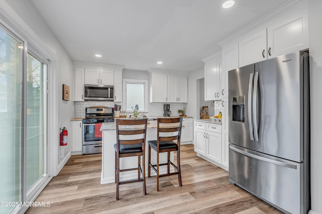 kitchen with a kitchen island, stainless steel appliances, and white cabinets