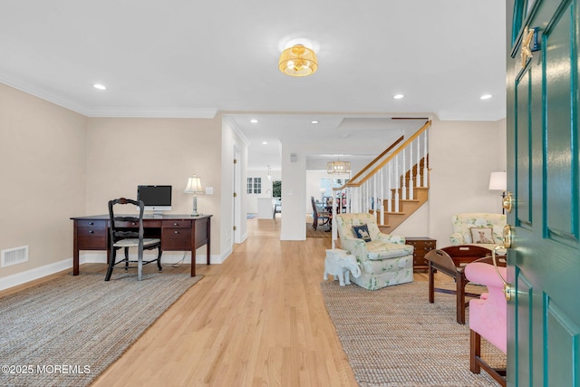 office area featuring baseboards, light wood-type flooring, visible vents, and crown molding