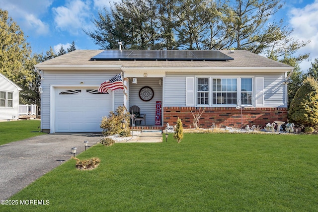 ranch-style house featuring a front lawn, a garage, and solar panels