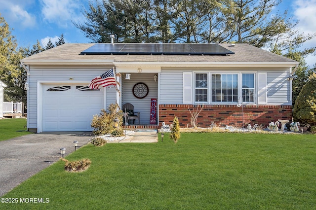 view of front of house with a garage, solar panels, and a front lawn