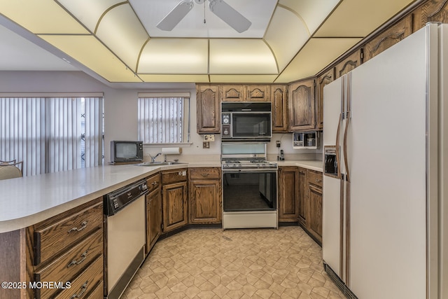 kitchen with white fridge with ice dispenser, kitchen peninsula, dishwashing machine, range with gas stovetop, and sink