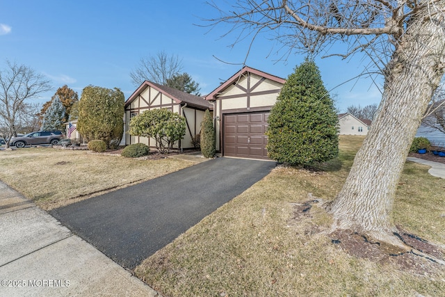 tudor-style house with a front lawn and a garage