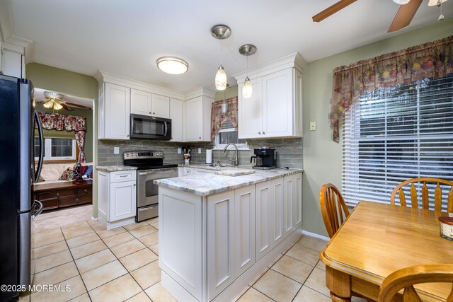 kitchen featuring white cabinetry, black refrigerator, hanging light fixtures, sink, and stainless steel electric range oven