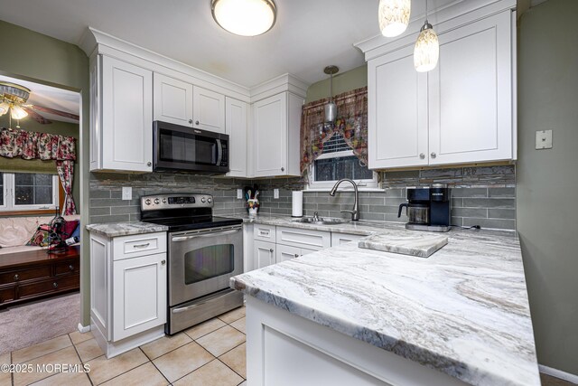 kitchen featuring stainless steel range with electric stovetop, white cabinetry, and pendant lighting