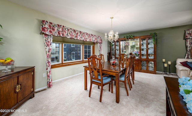 dining space featuring light carpet and an inviting chandelier