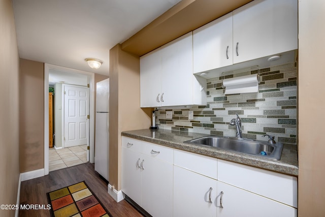 kitchen featuring white cabinets, sink, dark hardwood / wood-style floors, and tasteful backsplash