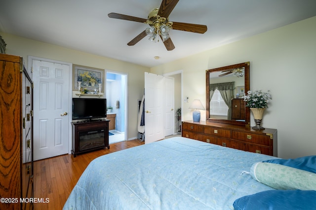 bedroom featuring connected bathroom, light wood-type flooring, and ceiling fan