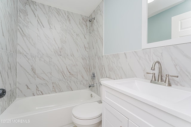 full bathroom featuring tile walls, vanity, tiled shower / bath, and toilet