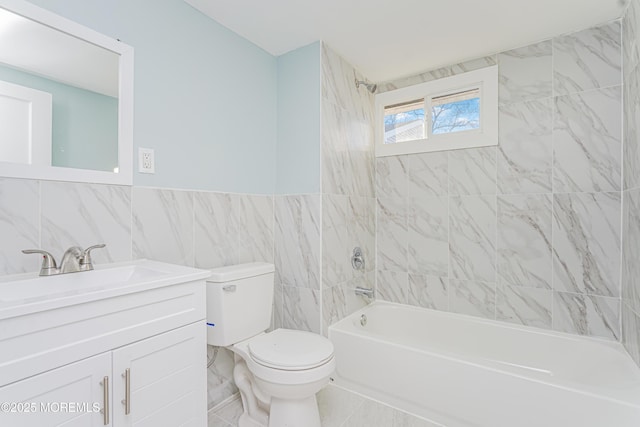 full bathroom with tiled shower / bath combo, vanity, tile walls, and toilet