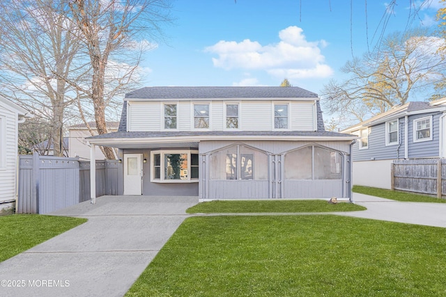 view of front of home featuring a front yard and a sunroom