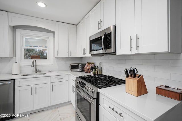 67 Grand Ave, Toms River, NJ 08753 - kitchen with white cabinets, decorative backsplash, appliances with stainless steel finishes, light countertops, and a sink