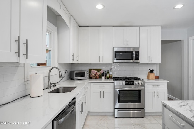 67 Grand Ave, Toms River, NJ 08753 - kitchen with appliances with stainless steel finishes, white cabinetry, a sink, and light stone counters