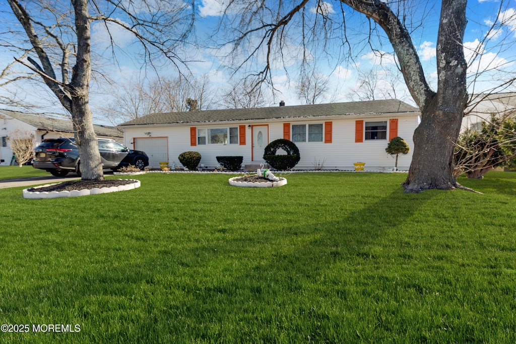 ranch-style home with a garage and a front lawn