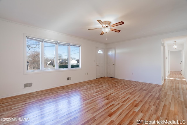 empty room featuring ceiling fan, ornamental molding, and light hardwood / wood-style floors