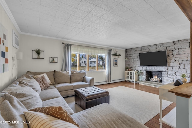 living room with ornamental molding, baseboard heating, light wood finished floors, and a fireplace