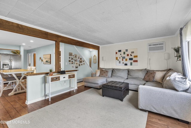 living room with dark wood finished floors, ornamental molding, a wall unit AC, and stairway