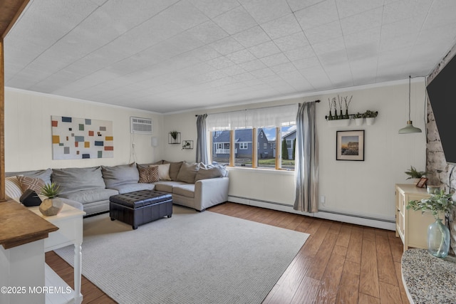 living room featuring baseboard heating, a wall unit AC, crown molding, and wood finished floors