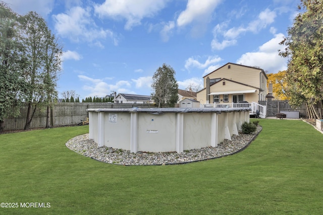 view of yard with a fenced in pool, a fenced backyard, and a wooden deck