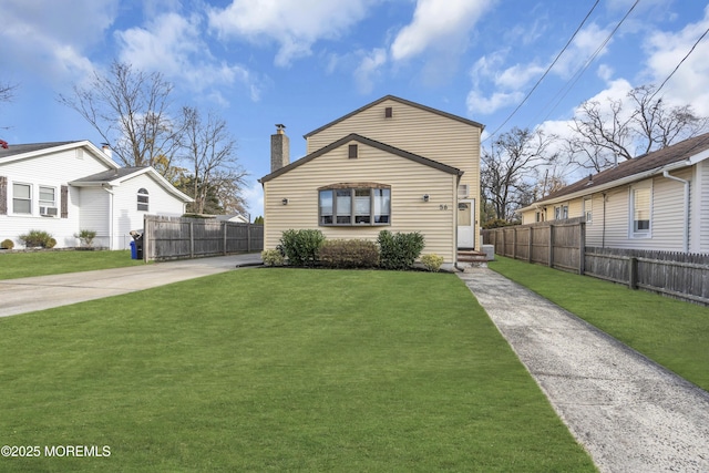 view of front facade with a chimney, fence, and a front lawn