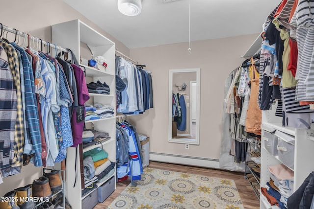 spacious closet featuring a baseboard radiator, attic access, and wood finished floors