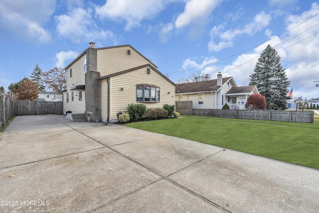 exterior space featuring a chimney, fence private yard, and a yard