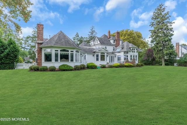 view of front of home featuring a front lawn, a chimney, and fence