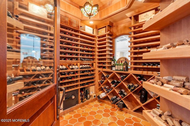 wine cellar with ornamental molding and a chandelier