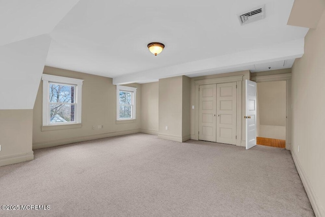 bonus room featuring baseboards, visible vents, and light colored carpet