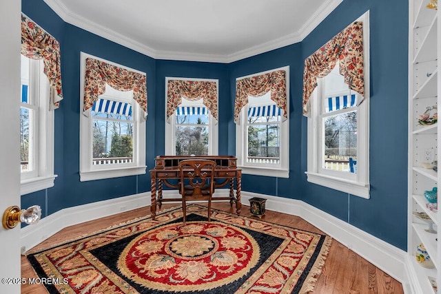 dining room with ornamental molding, wood finished floors, and baseboards