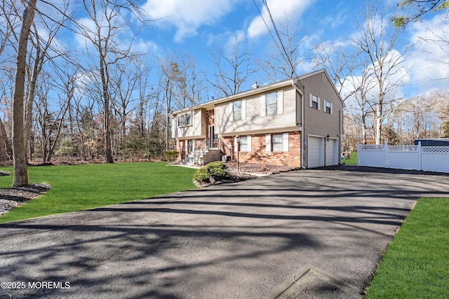 raised ranch featuring a front yard and a garage