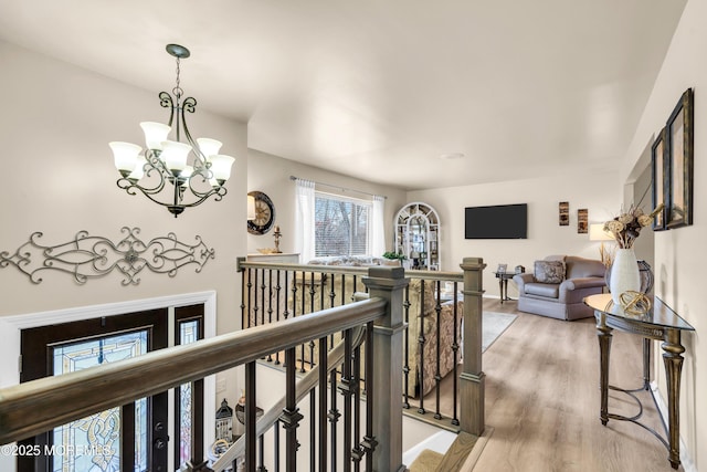 hall featuring hardwood / wood-style flooring and a chandelier