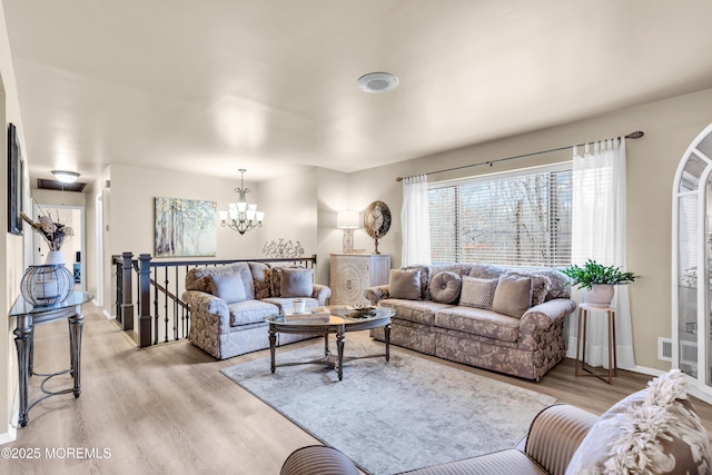 living room with light hardwood / wood-style floors and a chandelier