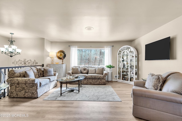 living room featuring light hardwood / wood-style floors and a chandelier