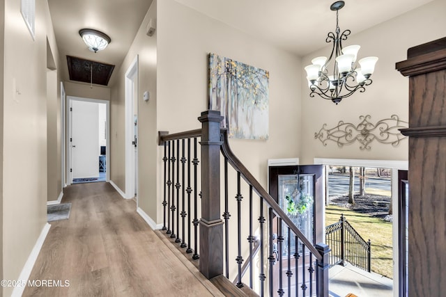 hallway featuring hardwood / wood-style flooring and a notable chandelier