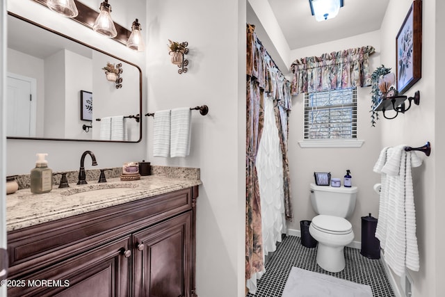 bathroom with toilet, tile patterned flooring, and vanity