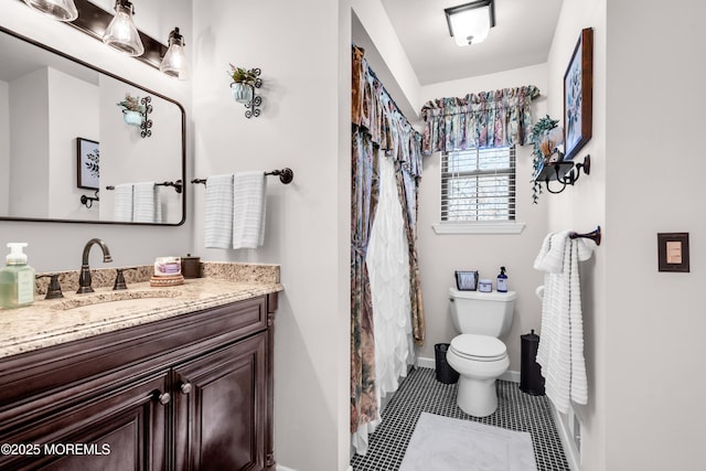 bathroom with toilet, tile patterned floors, and vanity