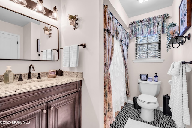 bathroom featuring vanity, toilet, and tile patterned flooring