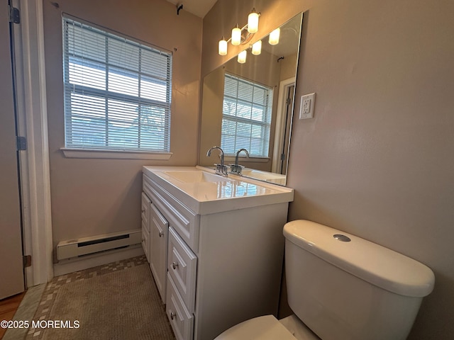 bathroom with a baseboard radiator, vanity, and toilet