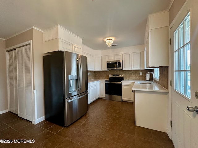 kitchen featuring a sink, light countertops, appliances with stainless steel finishes, and backsplash