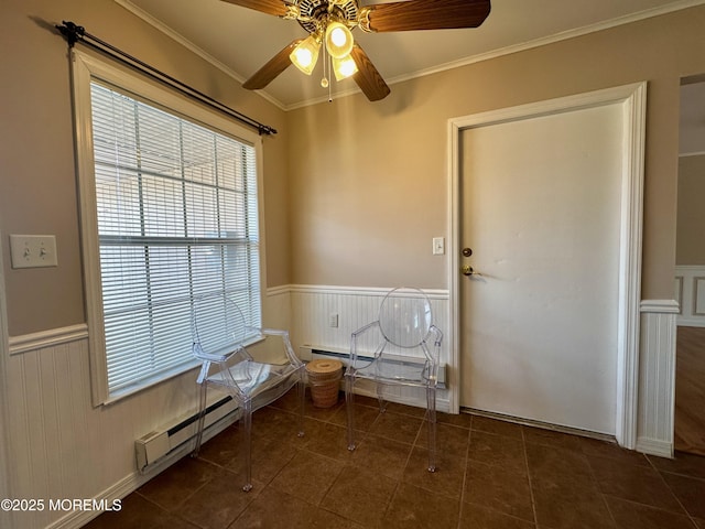 laundry room featuring ornamental molding, dark tile patterned flooring, a ceiling fan, and wainscoting