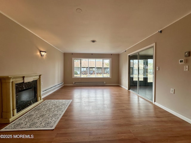 unfurnished living room with a baseboard radiator, a fireplace, crown molding, and wood finished floors