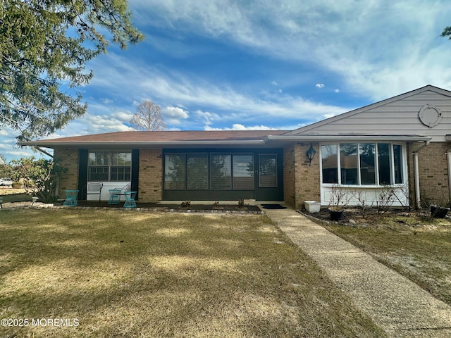 view of front of property with a front yard and brick siding